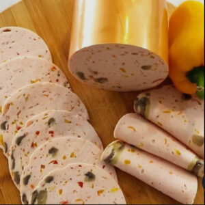 Sliced chicken and mushroom cold cut with vegetables on a wooden board